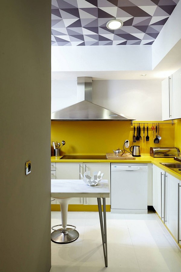 Căn bếp màu vàng rực rỡ của backsplash xen kẽ tủ bếp màu trắng tạo cái nhìn trung hòa.