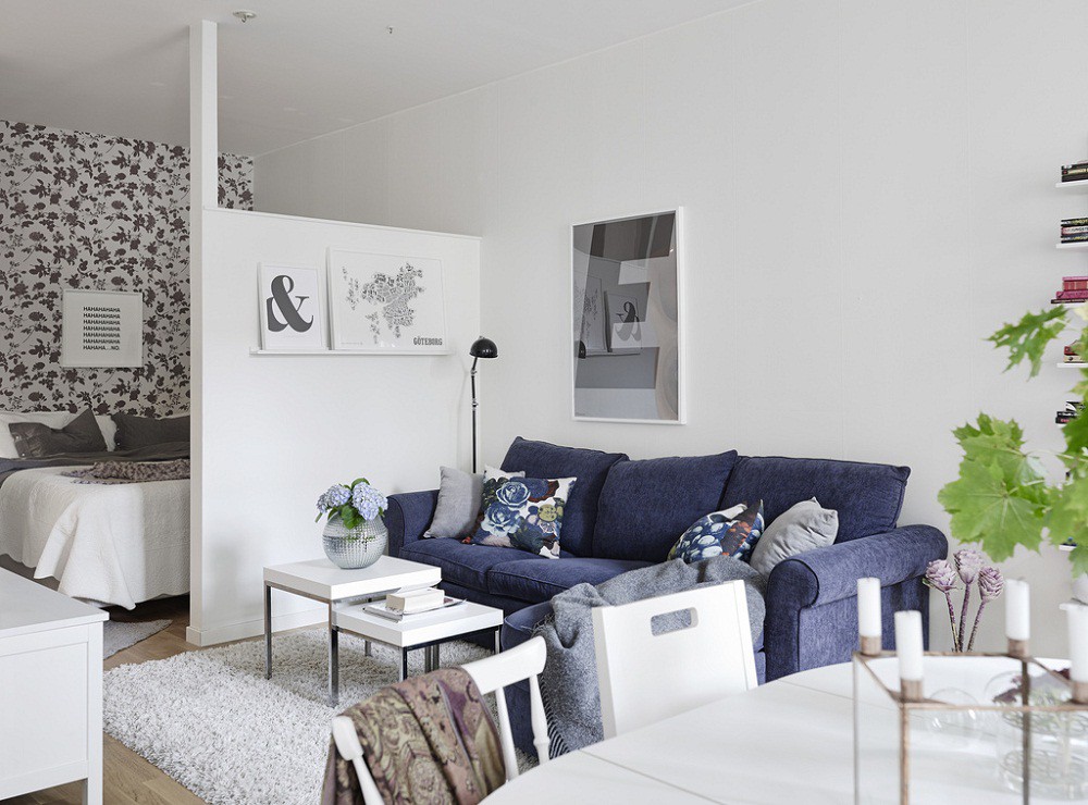 Bộ sofa xanh lam hút mắt nổi bật trên nền trắng như ngôi sao của gian phòng khách nhỏ này.