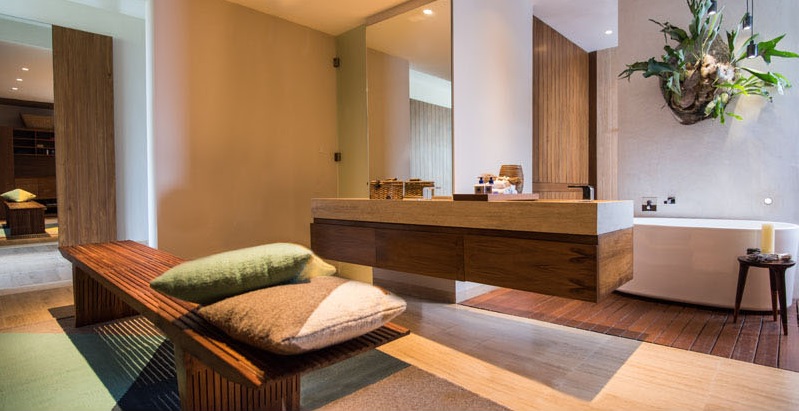 Chất liệu gỗ là chất liệu chủ đạo trong nhà, ngay cả trong phòng tắm nội thất gỗ vẫn là chủ đạo, bên cạnh đó còn có một bồn tắm trắng được đặt bên dưới một cây cảnh treo trên tường.